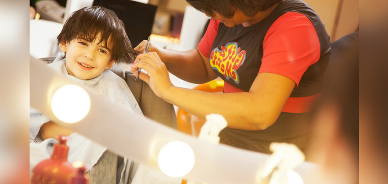 A beleza do cabelo e o barbeiro inclusivo aliciando a criança em